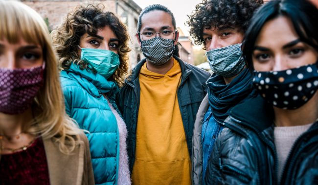 Multiracial young people with face mask looking at camera