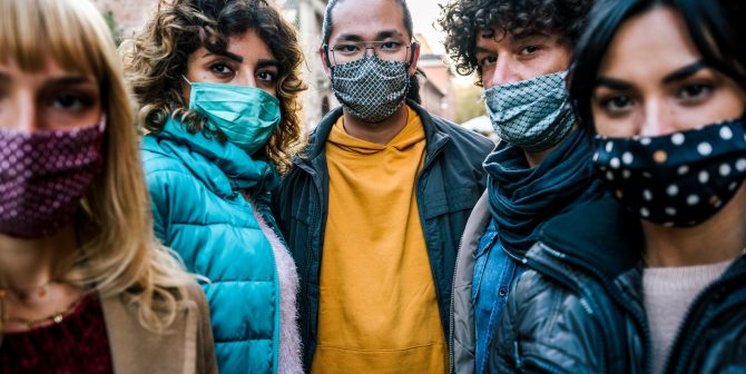 Multiracial young people with face mask looking at camera